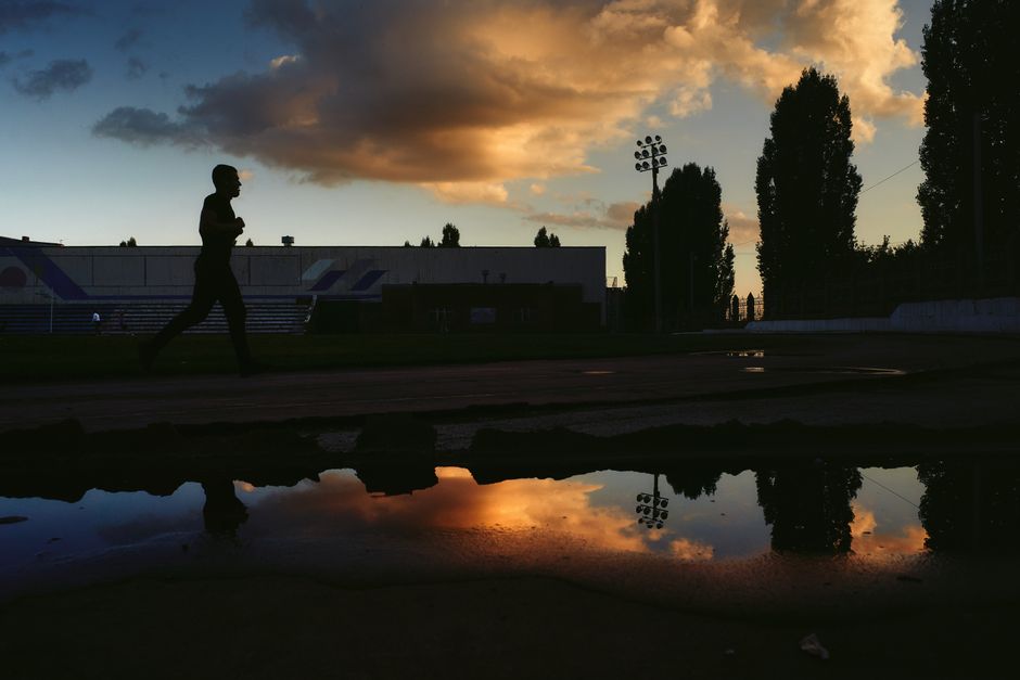 Coureur en silhouette sur une piste au coucher de soleil