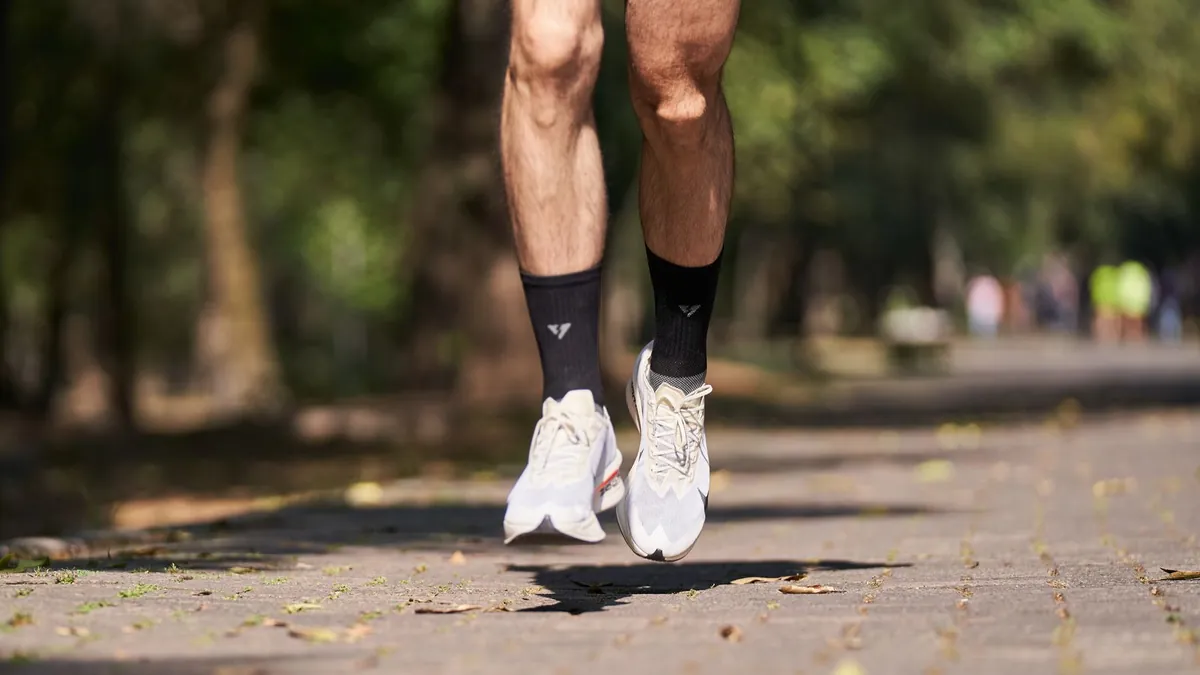 Gros plan sur les appuis d'un coureur en phase de suspension, illustrant la cadence de course