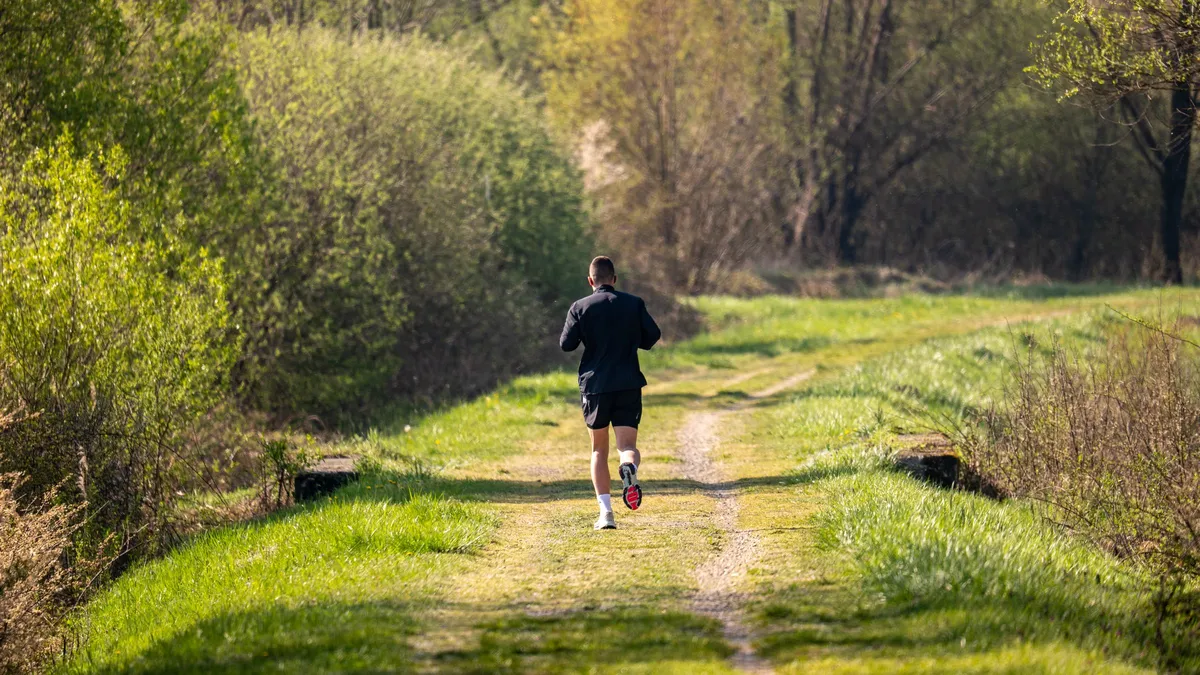 Coureur de dos respirant à l aise sur un sentier en forêt
