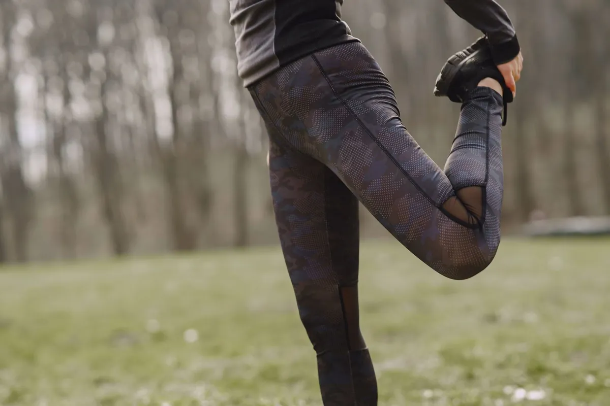 Coureur réalisant un étirement des quadriceps en collant après une sortie de course