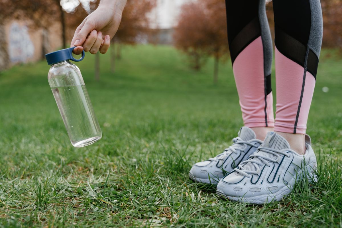 Chaussures de running et gourde d eau posees dans un parc
