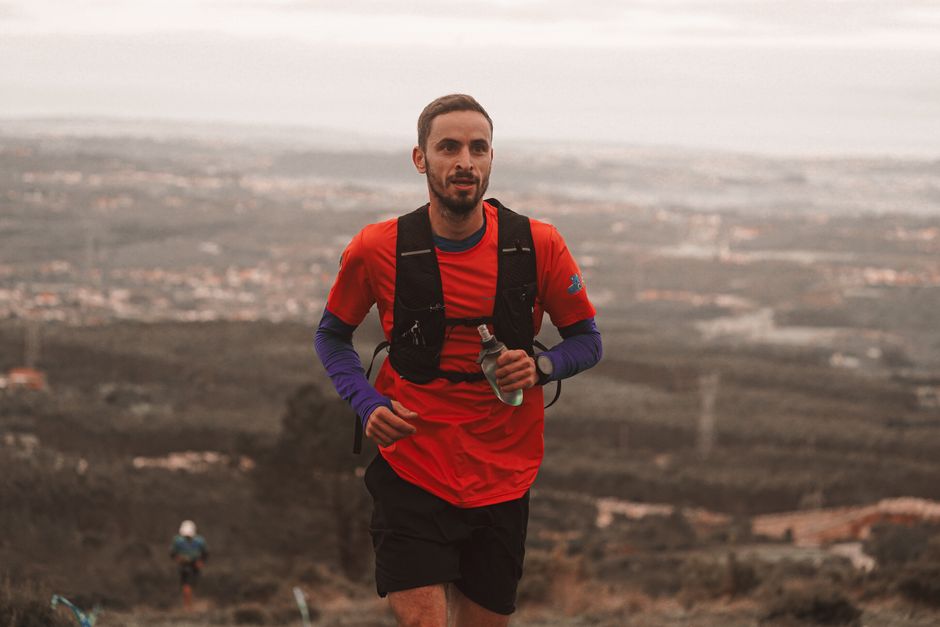 Coureur avec gilet d hydratation et flasque en trail